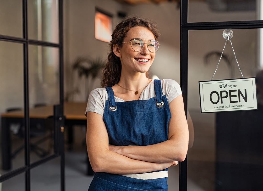 Business Insurance - Young Small Business Owner Standing at Cafe Entrance